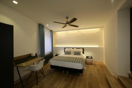 a bedroom with a bed and a ceiling fan at Les Maisons du Pont - Charme & Caractère in Aubusson