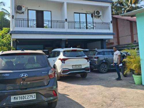 een man die op een parkeerplaats voor een huis staat bij STARFISH Resort in Nagaon