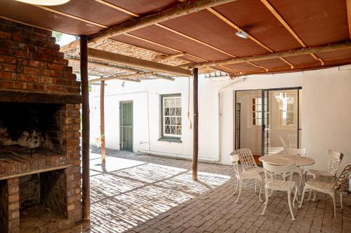 Cottage at 48 في غراف-رينيت: فناء به موقد من الطوب وطاولة وكراسي