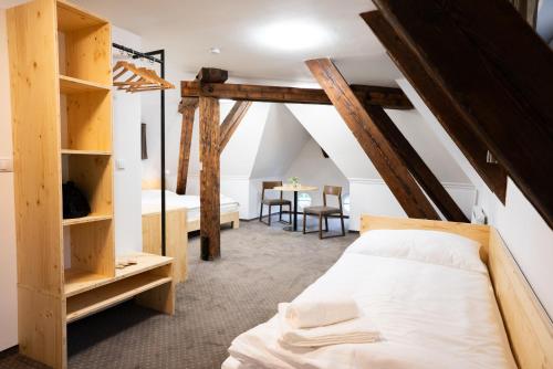a bedroom with a bed and a table with chairs at Zámecká Konírna Hotel a Restaurace in Liberec