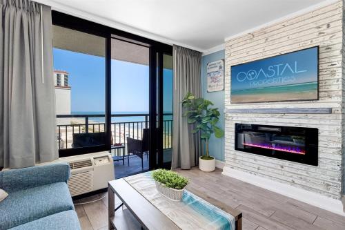 a living room with a fireplace with a view of the ocean at Gorgeous 1BR Oceanview Suite, Dogs OK 904 in Myrtle Beach
