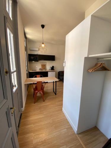 a kitchen and dining room with a table in a room at V2 Studio avec balcon, plein centre - 5 min Golfech in Valence-dʼAgen