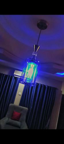 a room with a chair and a blue light at Abasis apartment in Abeokuta