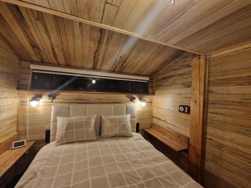 a bedroom with a bed in a room with wooden walls at Het boothuis in Velden