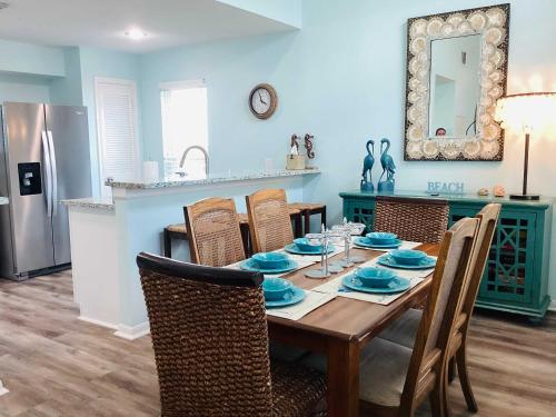 a dining room with a table and a kitchen at Saltwater Solace For 8 in Galveston