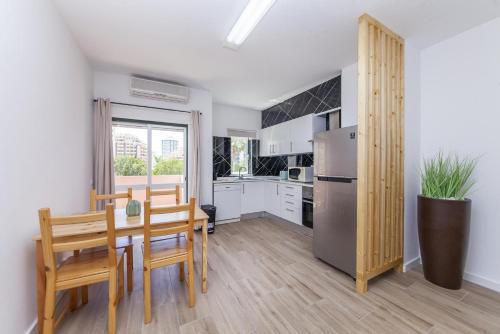 a kitchen with a table and chairs and a refrigerator at A50 - Castelos Apartment in Portimão in Portimão