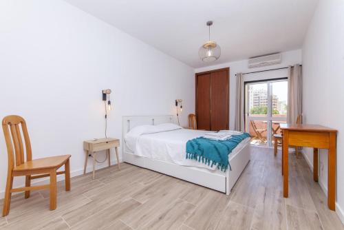a bedroom with a bed and a table and a desk at A50 - Castelos Apartment in Portimão in Portimão