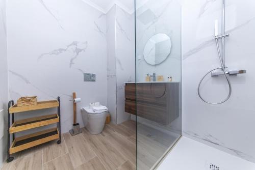 a white bathroom with a shower and a toilet at A50 - Castelos Apartment in Portimão in Portimão