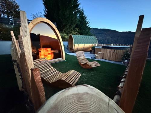 a yard with chairs and a fireplace in a house at Agritur Maso Librar in Trento