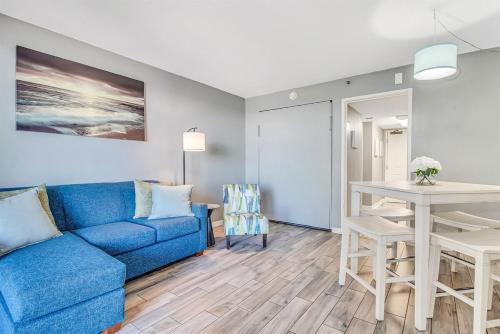 a living room with a blue couch and a table at Note worthy 1BR Oceanview Dogs OK! 438 in Myrtle Beach