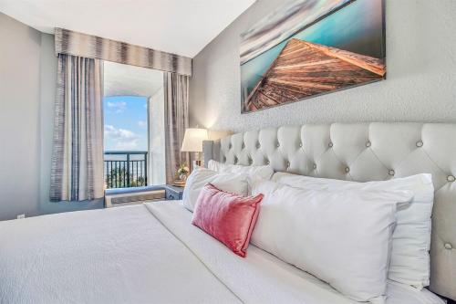 a bedroom with a white bed and a large window at Note worthy 1BR Oceanview Dogs OK! 438 in Myrtle Beach