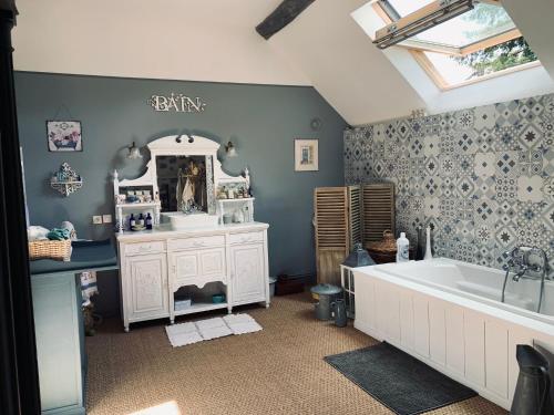 un bagno con vasca, lavandino e specchio di Chez Valerie et Francois a Moux-en-Morvan