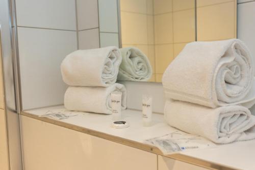 un mucchio di asciugamani seduti su un bancone in bagno di Hotel Work Life Residence am Bahnhof a Winterthur