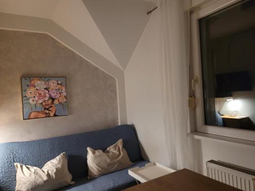 a living room with a blue couch and a window at APARTMANI Emerald Dream in Novi Sad