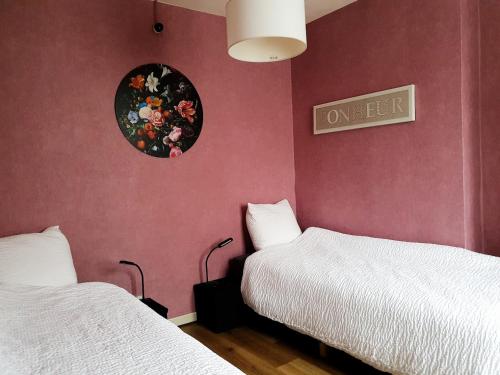 a room with two beds and a sign on the wall at Close to centre, 3 rooms, 2 bathr & wc, free parking & wifi, spacious living area & kitchen in Bruges