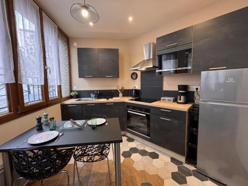 a kitchen with stainless steel appliances and a table at Le Sweety - Studio - 1 lit - 2 personnes in Châtel-Guyon