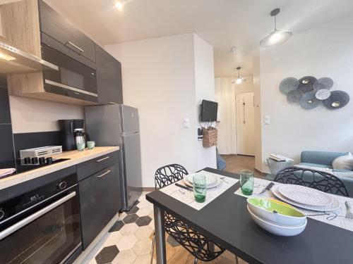 a small kitchen with a table in a kitchen with a counter top at Le Sweety - Studio - 1 lit - 2 personnes in Châtel-Guyon