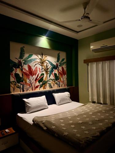 a bedroom with a bed with a painting on the wall at Hotel Maheshwar's Stay in Maheshwar
