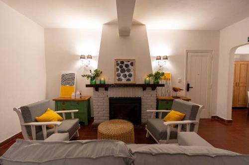 a living room with chairs and a fireplace at Madaro House in San Antonio de Arredondo