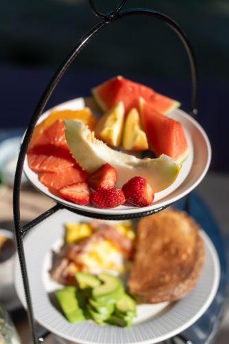 due piatti di cibo su un vassoio con frutta di Madaro House a San Antonio de Arredondo