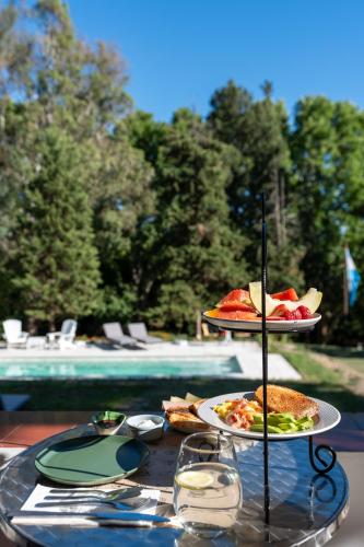 un tavolo con due piatti di cibo accanto a una piscina di Madaro House a San Antonio de Arredondo