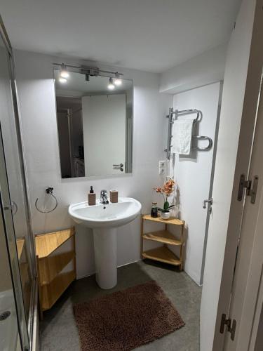 a white bathroom with a sink and a mirror at La Morada in Alcalá de Henares