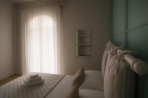 a bedroom with a white bed with a window at Villa Antonietta Ischia in Ischia