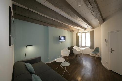 a living room with a couch and a table and chairs at Les Maisons du Pont - Charme & Caractère in Aubusson