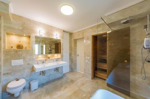 a bathroom with a toilet and a sink and a shower at Villa Grande in Odorheiu Secuiesc