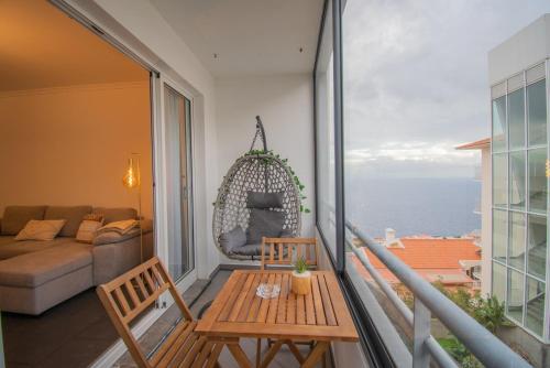 d'un balcon avec une table, des chaises et un canapé. dans l'établissement GuestReady - Charming Apartment with Ocean Views, à Nogueira