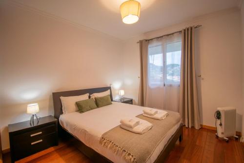 une chambre avec un lit avec deux serviettes dessus dans l'établissement GuestReady - Charming Apartment with Ocean Views, à Nogueira