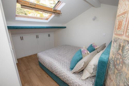 a bedroom with a bed with pillows and a window at Loft Moderne - À Deux Pas de Monte-Carlo in Roquebrune-Cap-Martin
