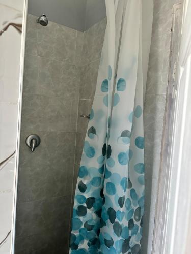 a shower with a blue and white shower curtain at Hatfield - Staylax Manor 3 in Harare