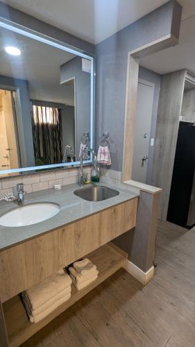 a bathroom with a sink and a large mirror at Ramada by Wyndham Medicine Hat in Medicine Hat