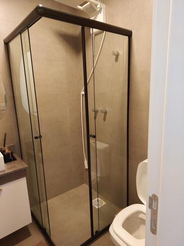 a glass shower in a bathroom with a toilet at Loft av central in Xangri-lá