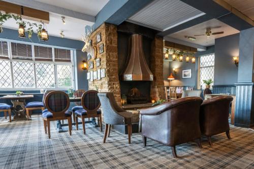 a living room with chairs and a fireplace at The Millstone Country Inn in Hathersage