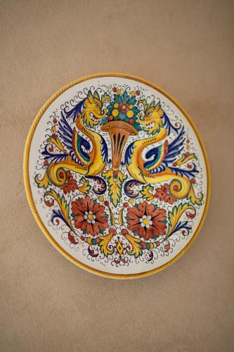 a plate with a floral design on a table at Don Carlo Agriturismo di Charme Bio in Le Pioppe