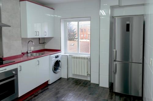 a kitchen with a sink and a refrigerator at Apartamento Los Colonia in Burgos