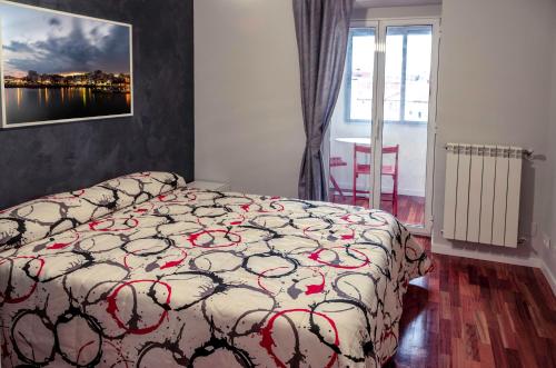 1 dormitorio con cama con edredón en Apartamento Los Colonia, en Burgos