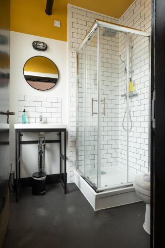 a bathroom with a glass shower and a sink at Malacuna Manchester in Manchester