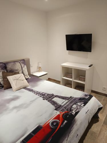 a bedroom with a bed and a flat screen tv at loue 2 chambres individuellemet chez l hote in Pia