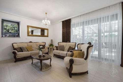a living room with two couches and a table at SPA vila na Golfe in Hrubá Borša