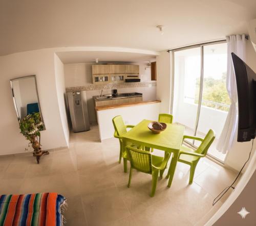 una cucina e una sala da pranzo con tavolo e sedie verdi di Apartamento Caribeño 1203 a Coveñas