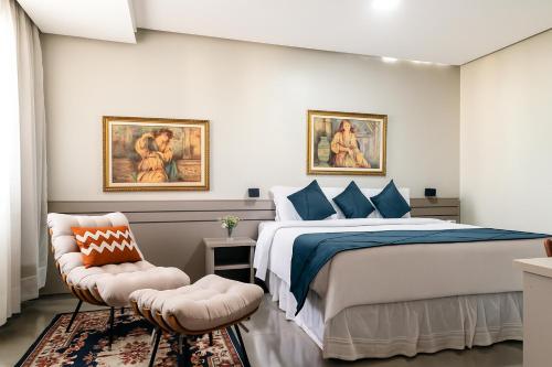 a bedroom with a bed and a chair at Hotel Dan Inn Uberlandia By Nacional Inn in Uberlândia
