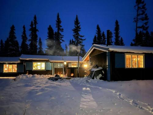 a house in the snow at night at Timber Cabin With Wood-Fired Hot Tub In Trysil in Granåsen