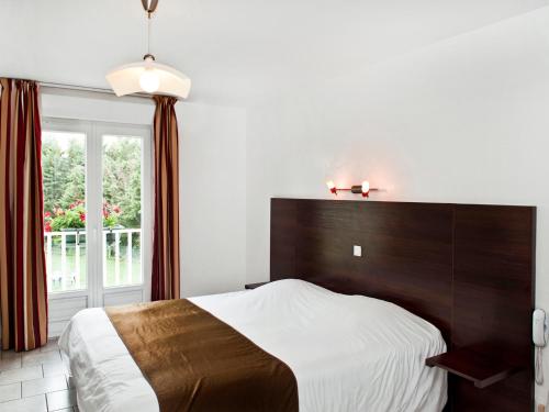 a bedroom with a large bed and a window at L'Orée des Châteaux in Bracieux