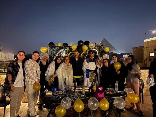 a group of people standing in front of a table with a pyramid at Giza Pyramids Inn in Cairo