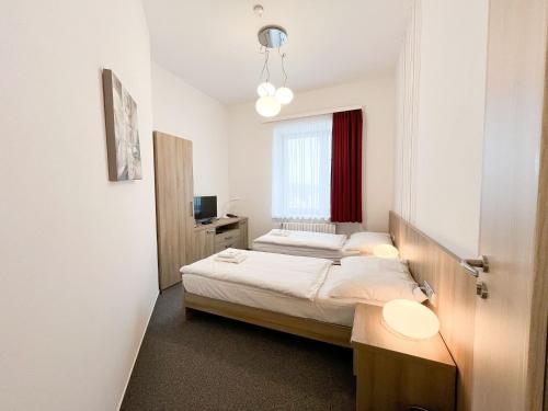 a bedroom with two beds and a window at Hotel Artaban in Žirovnice