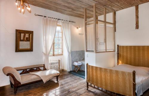 a bedroom with two beds and a large window at La Grande Maison in Chanteuges