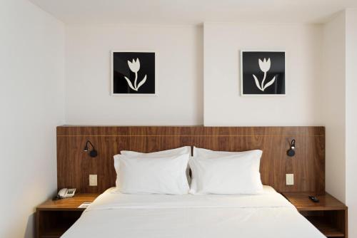 a bedroom with a bed and two pictures on the wall at Go Inn Taguatinga in Taguatinga